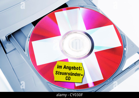 CD mit Schweizer Kreuz, beschriftet "zum Verkauf: steuerliche Steuerhinterziehern CD' in einem Computerlaufwerk Stockfoto