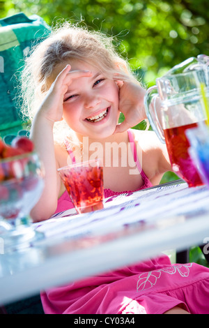 Mädchen an einem Gartentisch Stockfoto
