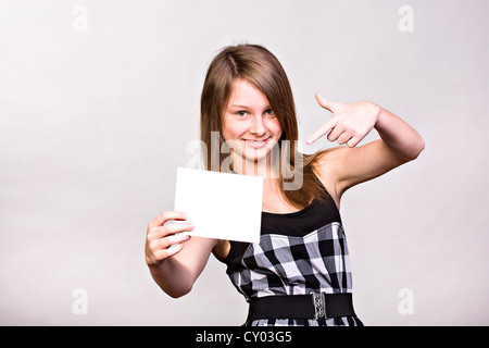 Teenager-Mädchen zeigt leeres Papier Stockfoto