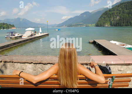 Eine Frau sitzt an einem See, genießen Sie die Sonne und Wolfgangsee See Region, Salzburg, Österreich, Europa Stockfoto