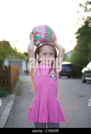 Drei-jährigen Mädchen spielen mit einem Ball, Rosenheim, Bayern Stockfoto