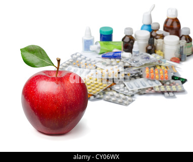 Roten Apfel vor einen großen Haufen von Arzneimitteln. Gesunder Lifestyle-Konzept. Stockfoto