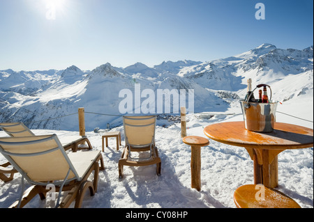Liegestühle und Tische, Blick auf schneebedeckte Berge, Tignes, Val d ' Isère, Savoie, Alpen, Frankreich Stockfoto
