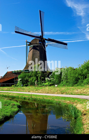 Niederlande, Nordholland, Zaanstad, Zaanse Schans, Windmühlen, Weg entlang des Kanals. Stockfoto