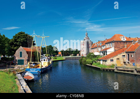 Niederlande, Enkhuizen, klassische holländische Schiffe im Kanal, Drommedaris Turm im Hintergrund. Stockfoto