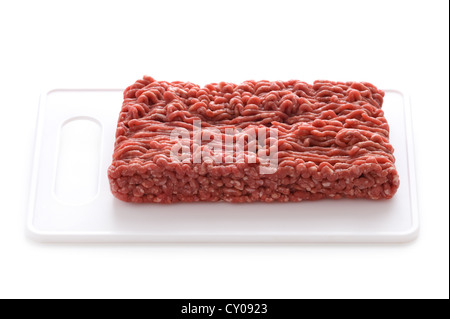 rohes Hackfleisch auf einem weißen Schneidebrett isoliert Stockfoto