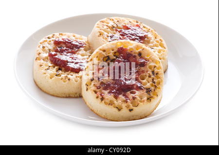 drei englische Fladenbrot mit Butter und Marmelade auf einem weißen Hintergrund isoliert Stockfoto