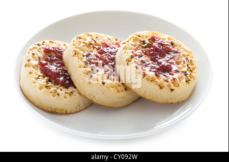 drei englische Fladenbrot mit Butter und Marmelade auf einem weißen Hintergrund isoliert Stockfoto