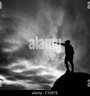 Männliche Figur stehen auf hohen Felsen in eine Richtung Stockfoto