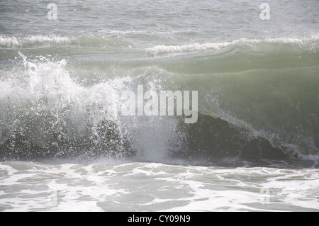 Eine große Welle brechen auf Chesil Beach, an der Küste von Dorset, bei stürmischem Wetter. England, United Kingdom. Stockfoto