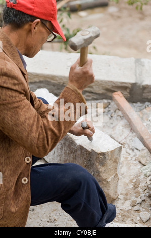 Ein Mann Hämmern einen Meißel auf Felsen am San Huang Zhai Kloster auf dem Song-Berg, China Stockfoto