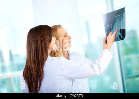 Porträt des jungen Arzt kommentierte Röntgen Prüfung führt zu ihrer Kollegin Stockfoto