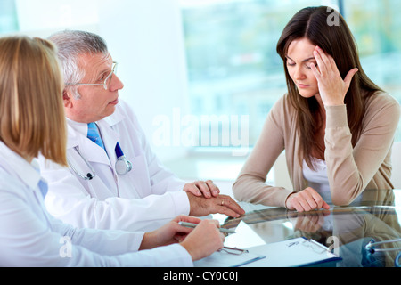 Porträt von zwei Praktikern, die Beratung von Patienten mit Kopfschmerzen im Krankenhaus Stockfoto