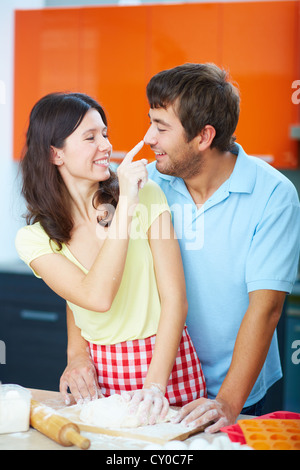 Porträt der jungen Mann seine Frau machen Spaß beim Kneten von Teig in der Küche Stockfoto