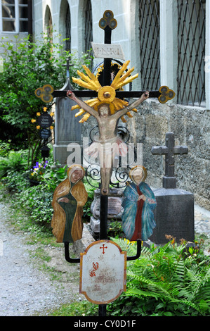 Alte bunte schmiedeeisernen Kreuz auf einem Grab, Friedhof St. Peter, die älteste christliche Grabstätte von Salzburg Stockfoto