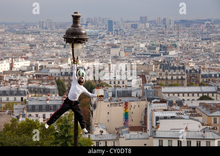 akrobatische Performance-Künstlerin auf eine alte Straßenlaterne auf die Hügel von Sacre Coeur und Montmartre und Paris Stockfoto