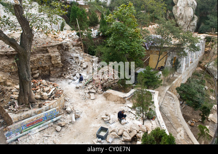 Arbeiter heben schwere Felsen im San Huang Zhai Kloster am Berg Song, China Stockfoto