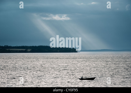 Mann in kleinen Boot auf Angeltour in der Nacht Stockfoto