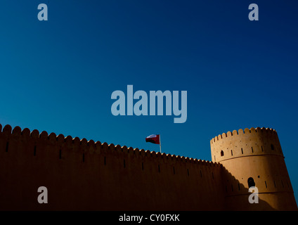 Wand des Sineslah Forts mit Flagge, Sur, Oman Stockfoto