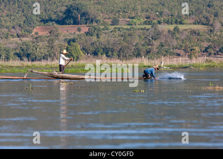 Myanmar, Burma. Fischer schlug das Wasser mit seinem Paddel, um Fische zu betäuben. Inle-See, Shan-Staat. Stockfoto