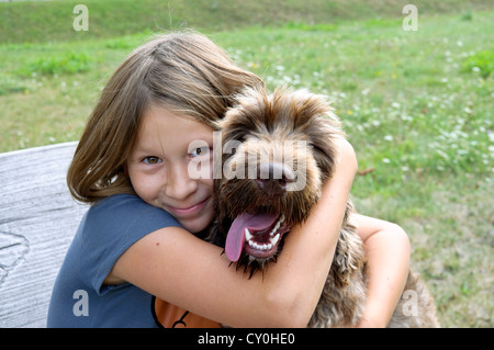 Junges Mädchen 10 Jahre alt kuscheln Mischling Hund. Stockfoto