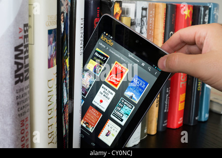 Google Nexus 7 Tablet-Computer mit kindle e-Book-Bibliothek-Anwendung und traditionellen Hardcover Papier Bücherregal