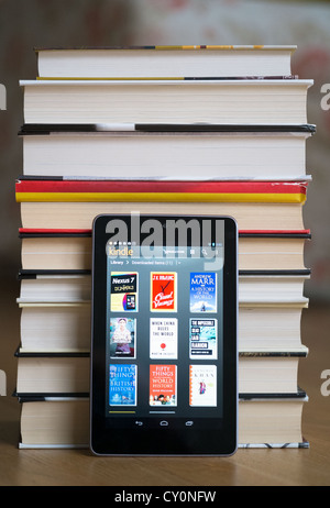 Google Nexus 7 Tablet-Computer mit kindle e-Book-Bibliothek-Anwendung und Haufen von traditionellen Hardcover Bücher