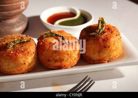 Dhokla ist eine vegetarische Nahrungsmittel, die von Gujarat in Indien stammt. Es ist mit einem gegorenen Teig Gramm Mehl gemacht. Stockfoto