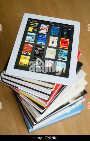 iPad Tablet-Computer mit kindle e-Book-Bibliothek-Anwendung und Haufen von traditionellen Hardcover Bücher Stockfoto