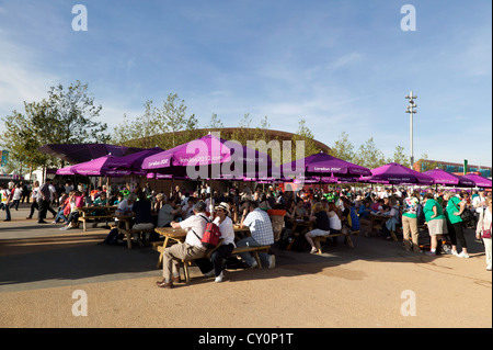 Besucher entspannen und schützen vor der Sonne unter Umberellen, im Olympic Park, Stratford, während der Sommer-Paralympischen Spiele 2012 Stockfoto