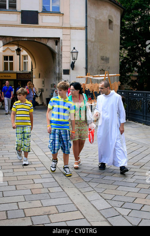 Touristen werden von einem Mönch in weißen Gewändern um Altstadt Bratislava geführt Stockfoto