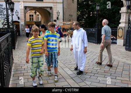 Touristen werden von einem Mönch in weißen Gewändern um Bratislava geführt Stockfoto