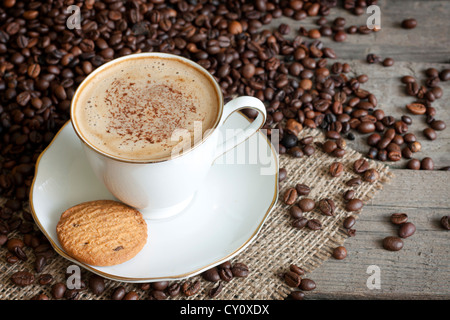 Cappuccino und Kaffee Bohnen Vintage Stilleben auf Holzbrettern Stockfoto