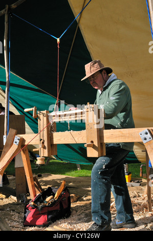 Mann, der Pole-Drehmaschine zeigt, auf einer Tretdrehmaschine, die Stuhlspindeln macht auf der Autumn Countryside Show, West Sussex, England, Großbritannien Stockfoto