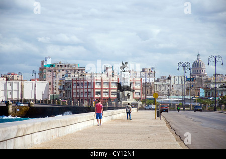 Menschen zu Fuß auf dem Malecon, Capitolio und City Skyline, sind Havanna, El Malecon und Capitolio eine kubanische Sehenswürdigkeiten in Havanna Stockfoto