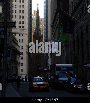 Am Nachmittag Schatten urbane Gasse Blick, Trinity Church, gelbes Taxi Transporter Autos bewegen Wall Street in Hanover Street, New York Stockfoto