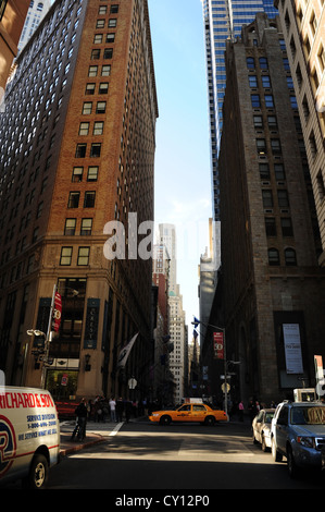 Blauer Himmel Sonne Schatten urbane Gasse Porträt, in Richtung Trinity Church, gelbes Taxi bewegen Pearl Street, überqueren die Wall Street, New York Stockfoto