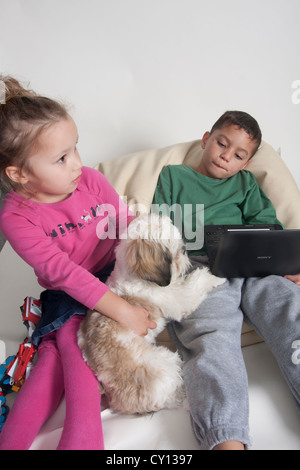 kleine Jungen und Mädchen streiten sich um Welpen Stockfoto