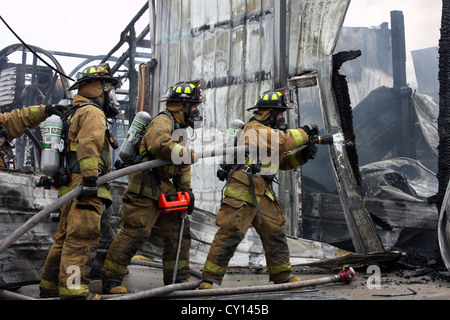 Feuerwehr zu Wasser auf einem industriellen Feuer setzen Stockfoto