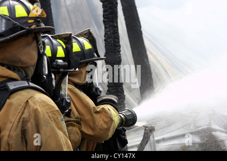 Aufsprühen von Wasser auf einem Feuer Lannon Feuerwehr Feuerwehr team Stockfoto