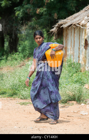 Indische Dorf Frau sammeln von Wasser aus einem kommunalen Wassertank. Andhra Pradesh, Indien Stockfoto