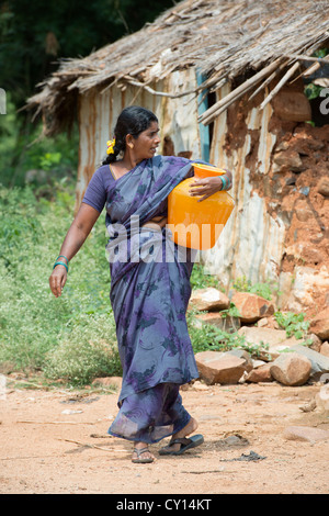 Indische Dorf Frau sammeln von Wasser aus einem kommunalen Wassertank. Andhra Pradesh, Indien Stockfoto