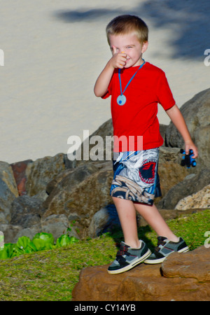 Ein fünf-jähriger Junge mit Autismus gibt ein seltenes "Daumen hoch" in die Kamera. Stockfoto