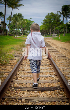 Ein fünf-Jahr-alten autistischer jungen geht gespannte entfernt auf Eisenbahnschienen. Stockfoto