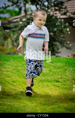 Ein fünf-Jahr-alten autistischer jungen läuft mit einem Stein in der hand; spielt er nur? Stockfoto