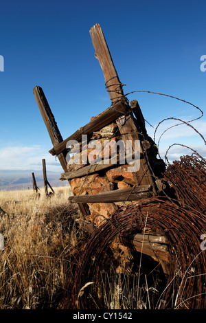 Ein Rock-Jack Anker einen Stacheldrahtzaun in steinigen Wüstengebiet, Yakima Rim Skyline Trail, Yakima, Washington Stockfoto