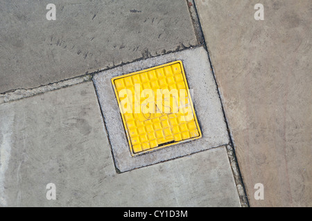 Gas-Einsteigeloch-Abdeckung im Pflaster, UK Stockfoto