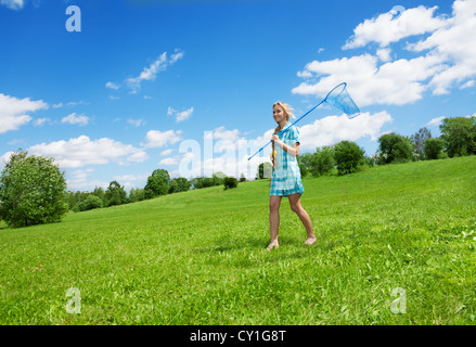 glücklich hübsches Mädchen mit Schmetterling net stehen auf dem grünen Rasen Stockfoto