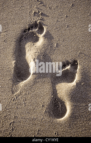 Zwei Fußspuren im Sand des Strandes Stockfoto