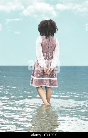 Frau mit Vintage-Kleid im Wasser stehend Stockfoto